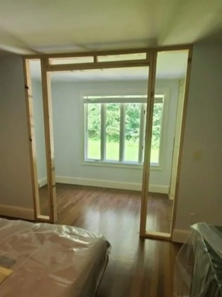 The finished wood stud structure of an interior doorway framing completed by Lira Home Improvement.