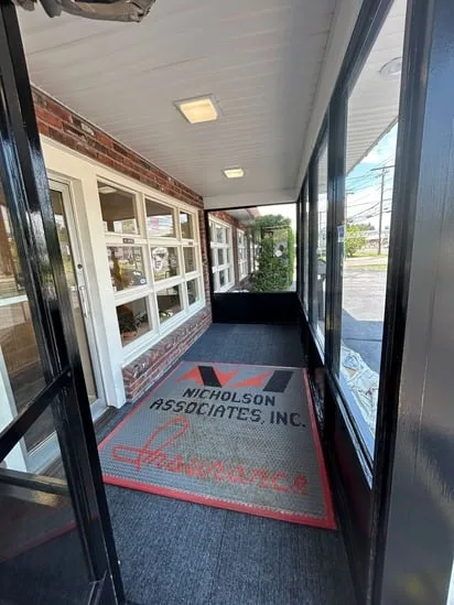 Wide view of the commercial entryway showing the newly installed carpet runner and overhead lighting.