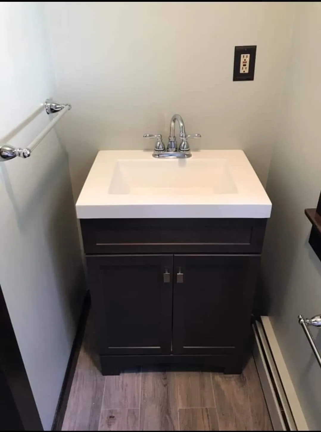 A detailed view of a bathroom vanity renovation featuring a newly installed sink and faucet in a compact residential space.
