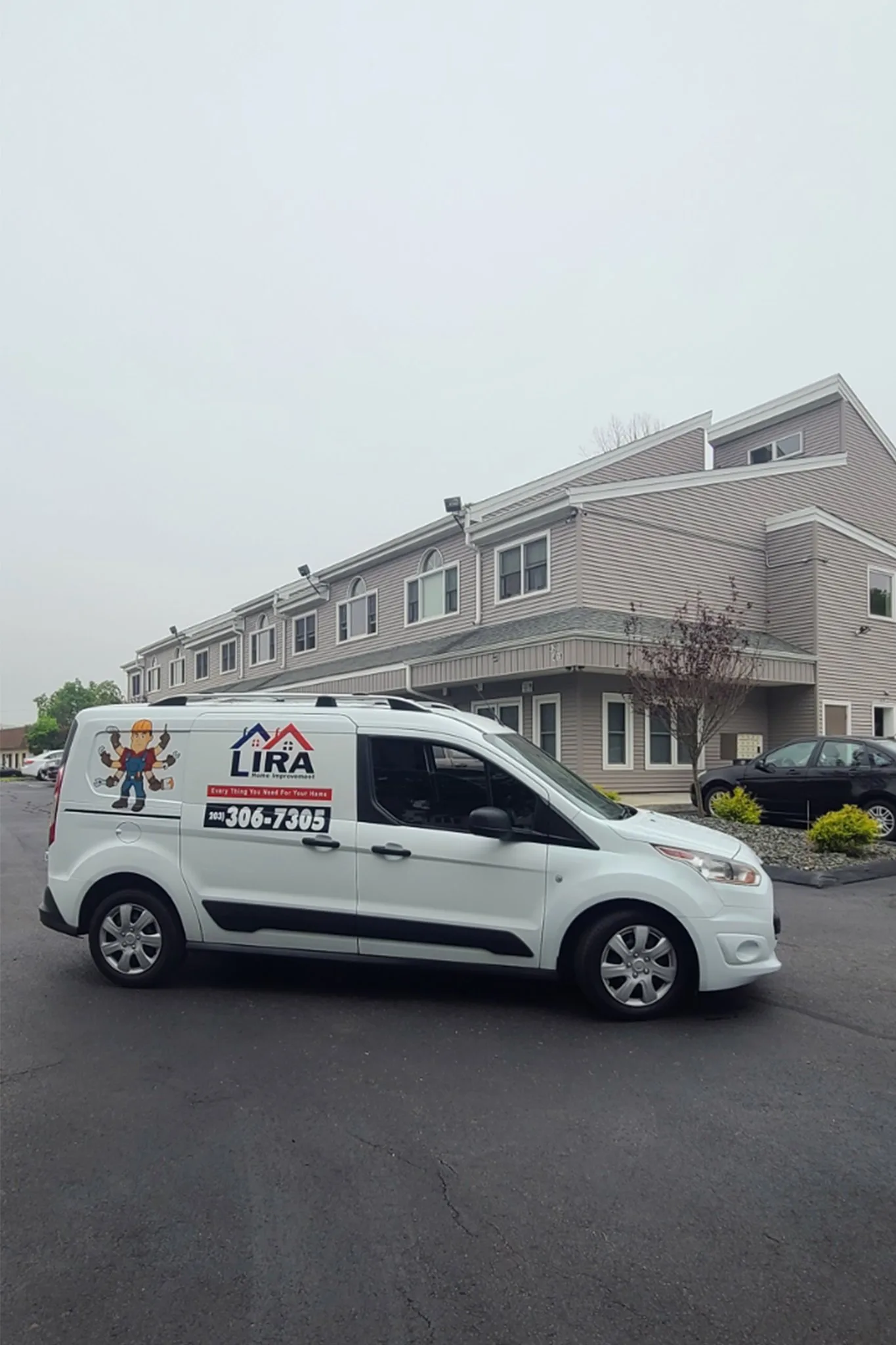 A company service van parked at a large residential complex following exterior multi-family painting work.