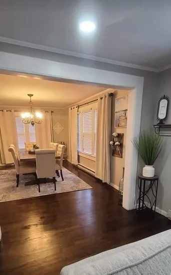 The completed home interior renovation featuring dark hardwood floors, a furnished dining set, and decorative wall art.